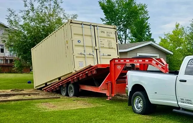 Preparing Your Site for Container Delivery Canada with a leveled gravel base and delivery truck positioning a shipping container onsite.